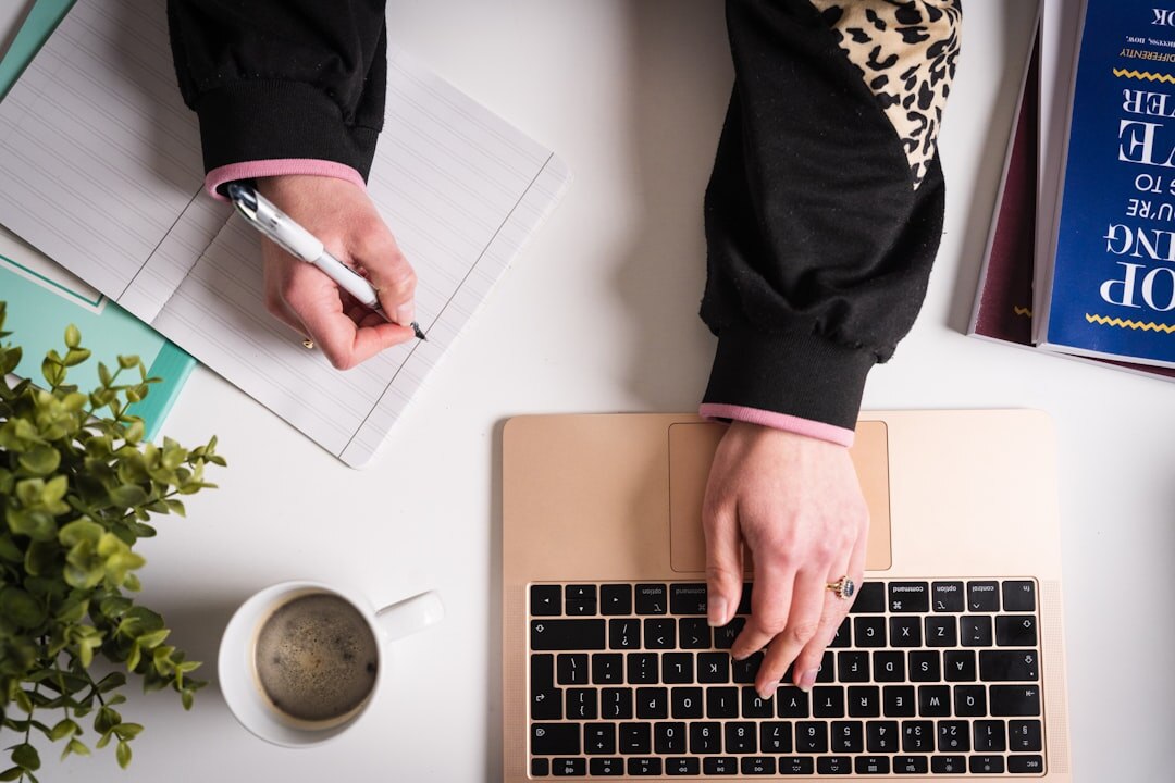 person writing on laptop